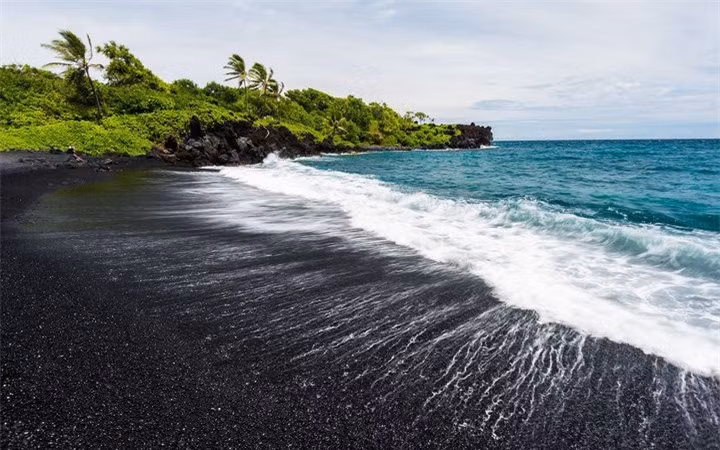  Bãi biển Punalu’u (Hawaii):Hình thành bởi các mảnh vụn nham thạch sau trận phun trào núi lửa, nơi đây trở thành một trong những địa điểm du lịch hấp dẫn với vẻ đẹp huyền bí của bãi cát biển màu đen. Du khách có thể nép mình dưới bóng mát của những hàng dừa xanh, tận hưởng không khí trong lành, ngắm nhìn khung cảnh thần tiên của biển cả. Ảnh:Travel + Leisure.