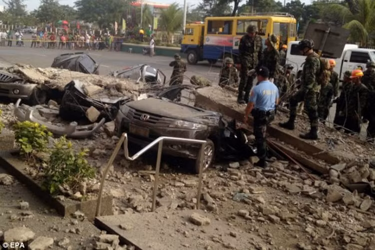Binh lính Philippines tìm kiếm nạn nhân trong xe bị khối bê tông đè bẹp bên ngoài một trung tâm mua sắm.