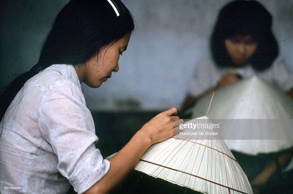 Người phụ nữ làm nón trong một xưởng sản xuất nón bài thơ ở Huế, 1989. Ảnh: Francoise De Mulder/ Getty Images.