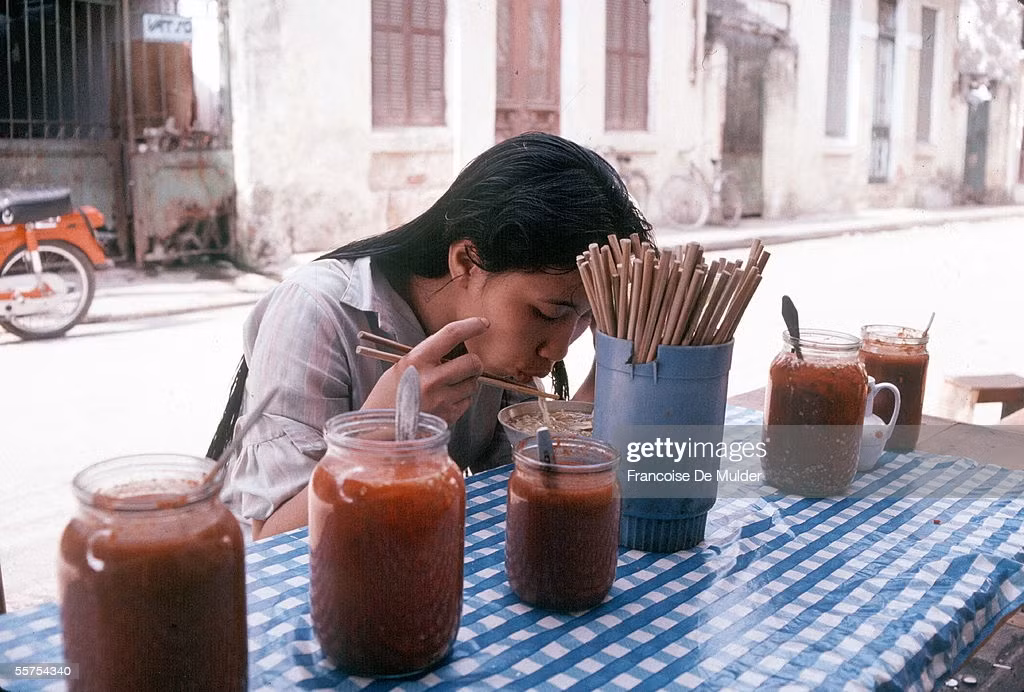Cô gái thưởng thức bữa sáng trên vỉa hè Hà Nội, 1989.