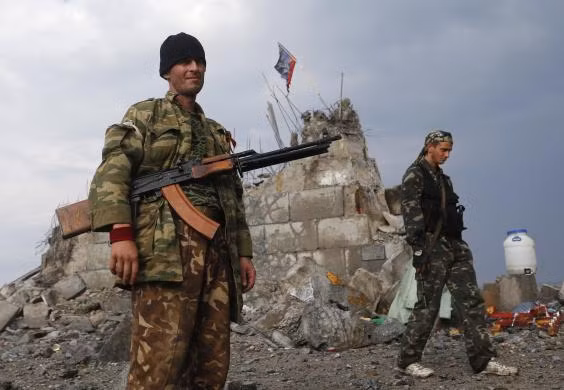 Dân quân tự vệ thân Nga đi qua khu vực tượng đài chiến tranh bị phá hủy ở Savur-Mohyla, Donetsk ngày 28/8.
