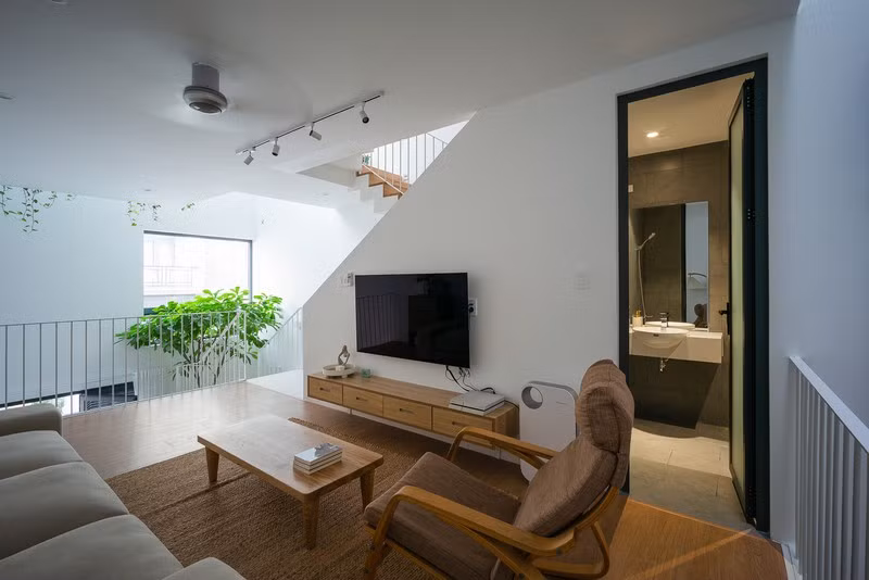Nội thất tối giản tích hợp các chức năng với màu trắng và gỗ làm màu chủ đạo để tạo nền cho ánh sáng, cây cối.