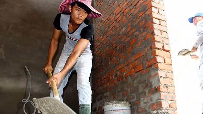 Nguyễn Hoàng Tín quần quật làm phụ hồ để kiếm tiền nhập học - Ảnh: Ngọc Dương.