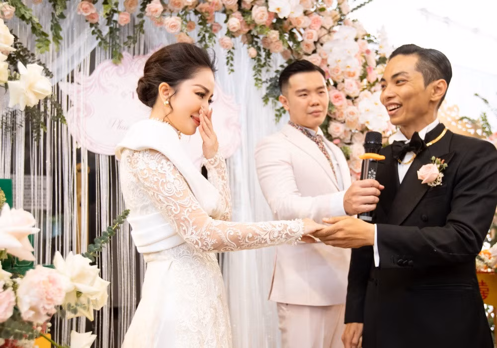 Đáp lại lời chồng, Khánh Thi cũng bật khóc nức nở. Cô cho biết trong suốt nhiều năm qua mình thực sự hạnh phúc với vai trò làm vợ, làm mẹ dù chưa có một lễ cưới. “Hôm nay lại được anh rước về làm dâu và được mặc áo cưới nữa. Em yêu anh", cô nghẹn ngào.