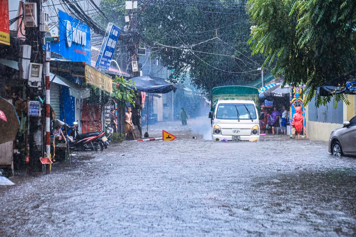 Trận mưa lớn khiến tuyến đường Nhật Tảo ngập sâu 20 - 30 cm, các phương tiện di chuyển khó khăn.