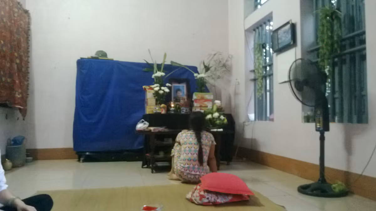 Người mẹ trẻ khóc bên di ảnh nạn nhân.