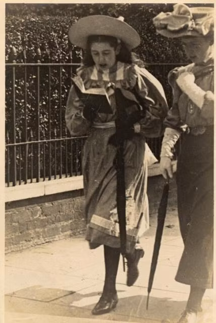 Một cô gái trẻ đọc sách khi đi trên phố ở London, khoảng năm 1900. Ảnh: Vintag.