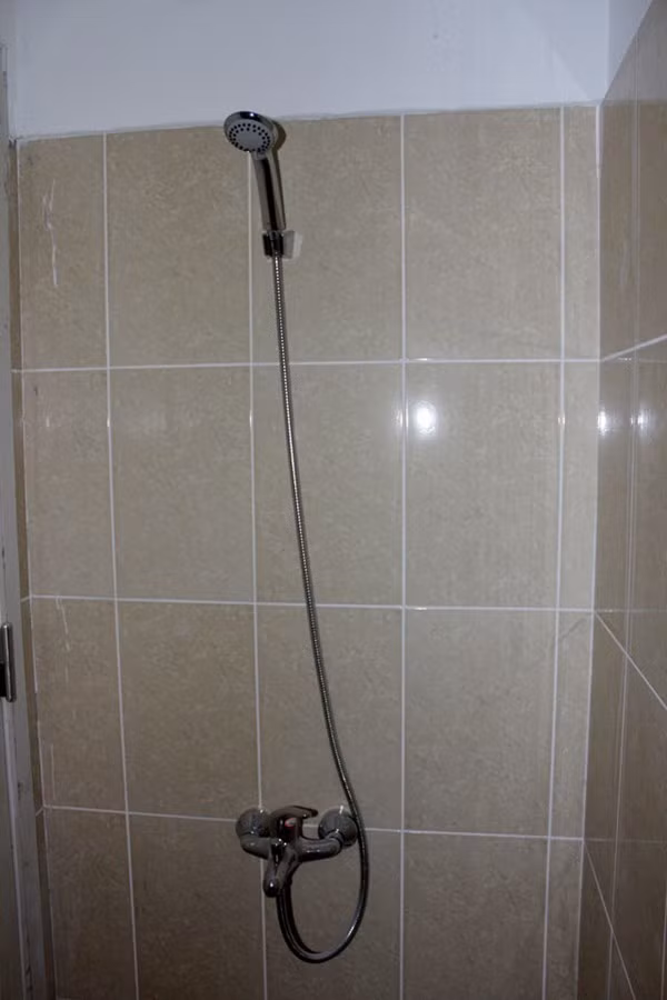Vòi tắm hoa sen được lắp trong phòng tắm của khu vệ sinh.