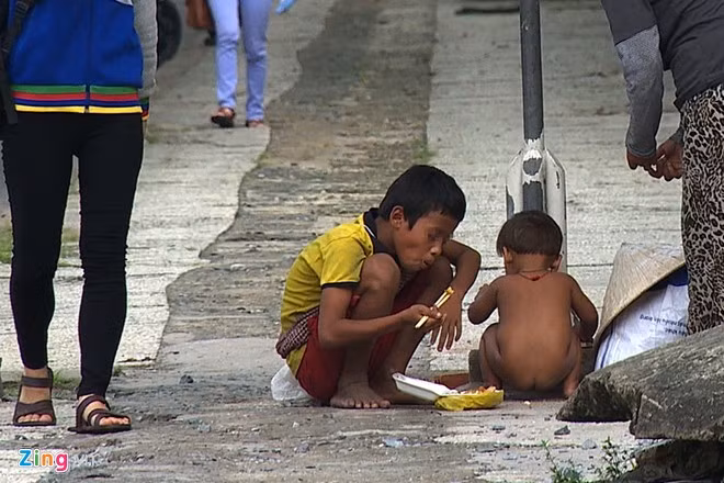 Sau một buổi sáng, những đứa trẻ ăn trưa với cơm hộp và chơi chốc lát ngay bên lề đường.