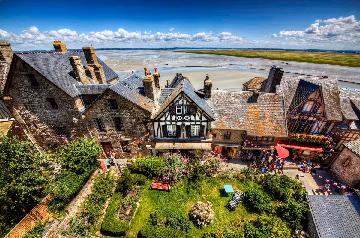 Quanh Mont Saint Michel đã hình thành một thị trấn nhỏ với các dịch vụ nhằm đáp ứng nhu cầu sinh hoạt của người dân trên đảo và du khách thập phương. Ảnh: Odyssey Traveller.