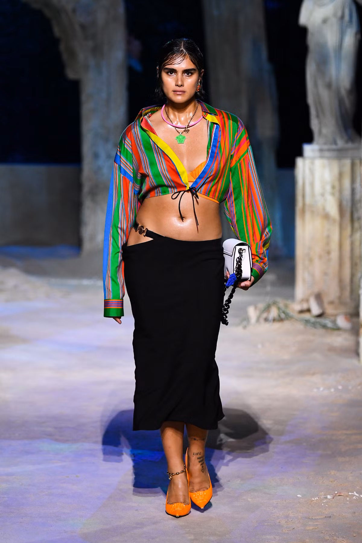 Versace lại có cách cập nhật xu hướng áo crop top bằng tinh thần trẻ trung hơn khi phối nhiều màu sắc với đường kẻ sọc dày và mỏng khác nhau. Cách làm này tạo hiệu ứng thon gọn hơn cho các cô nàng có thân hình mũm mĩm. Ảnh: Vogue.