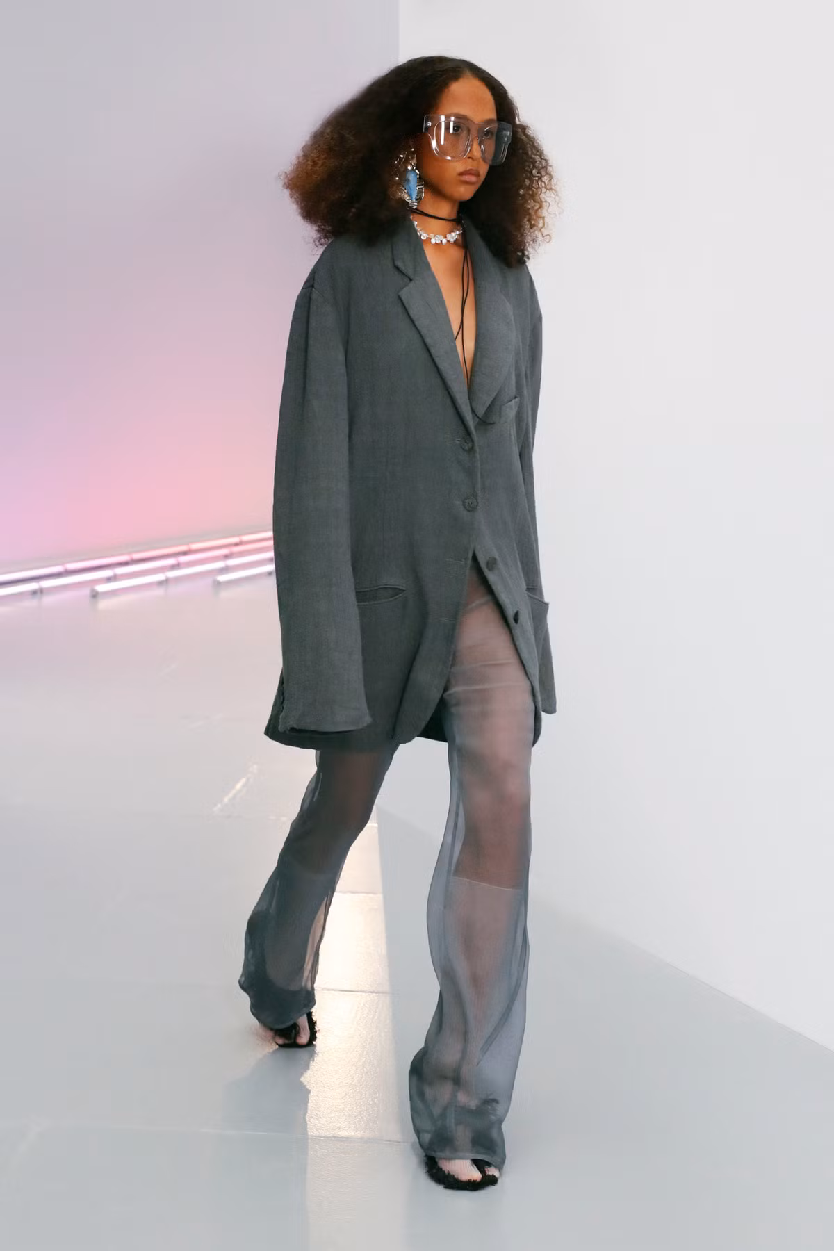 Acne Studios trông sành điệu hơn khi hòa quyện chất liệu vải sheer cùng phom dáng quần ống suông đi kèm blazer quá khổ đậm tinh thần menswear. Sự pha trộn giữa tông màu xám đậm và nhạt hay chất liệu vải khác nhau là điểm nhấn cho xu hướng ăn mặc gợi cảm năm 2021. Ảnh: Vogue.