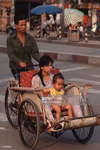 Người mẹ trẻ và đứa con trên chuyến xích lô ở Sài Gòn. Ảnh:Peter Charlesworth / Getty.