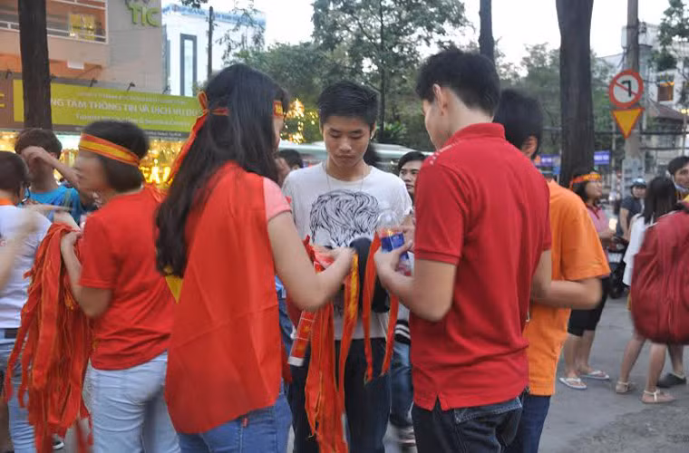 Nhiều bạn sinh viên bán băng ron, cờ, nón với dòng chữ Việt Nam chiến thắng, Việt Nam vô địch...
