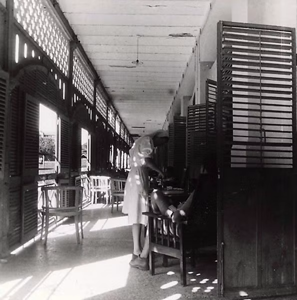 Một quân nhân được y tá chăm sóc tại hành lang của Bệnh viện Grall năm 1947. Sau ngày thống nhất đất nước, bệnh viện được chuyển giao cho chính quyền cách mạng.
