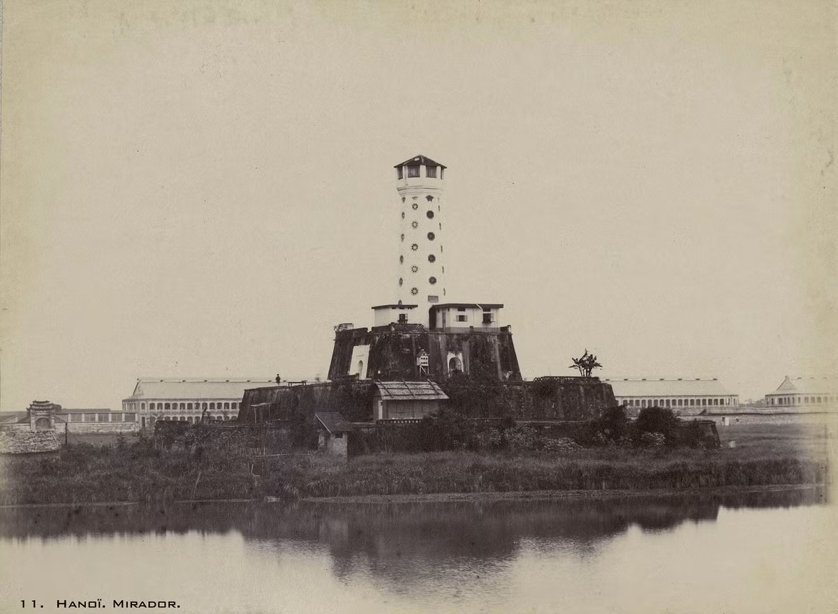 Cột cờ ở phía Nam thành Hà Nội năm 1899. Lúc này trước cột cờ có hào nước, trên cột cờ có chuồng bồ câu và một số gian nhà do người Pháp xây dựng. Sau cột cờ là khu doanh trại của quân đội Pháp.