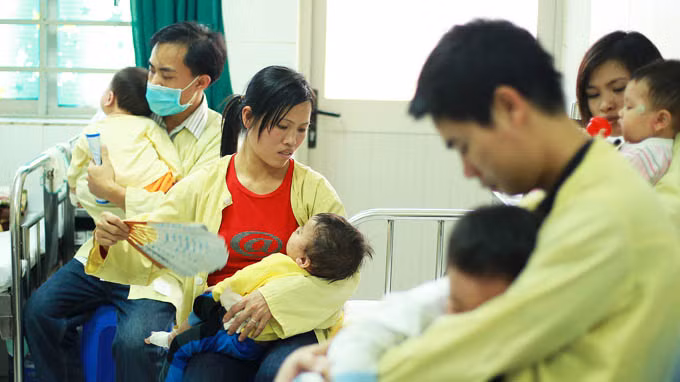 Các bệnh nhi điều trị bệnh sởi đang được người thân chăm sóc (ảnh chụp tại Bệnh viện Nhi trung ương vào tháng 2-2014).