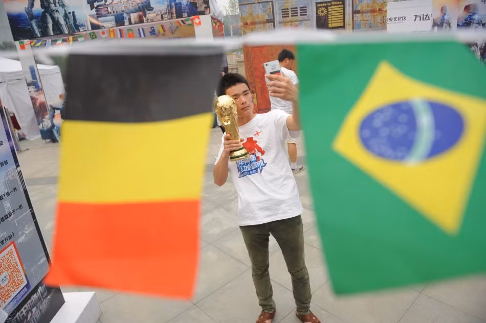 Một thanh niên đang pose hình với vẻ mặt rất nghiêm túc bên chiếc cup vàng vừa mua.