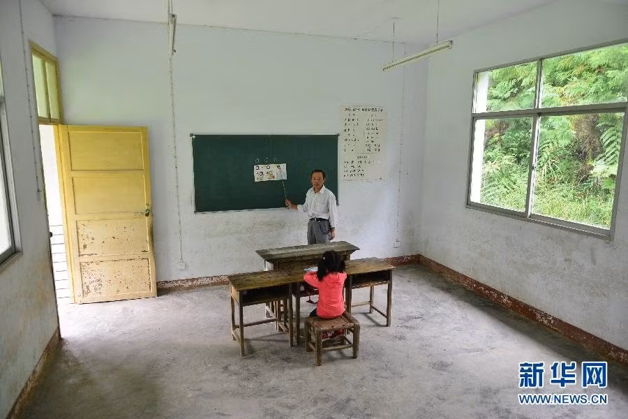 Hình ảnh được chụp tại một ngôi làng tại miền núi Enshi, Hồ Bắc, Trung Quốc. Qua ảnh có thể thấy cả ngôi trường chỉ có một thầy giáo và một học sinh. Cô bé là Liu Xinyi, năm nay 6 tuổi, đến trường để học những chữ cái đầu tiên của cuộc đời. Không có bạn bè, không có các anh chị lớp trên, chỉ có một mình Liu và người thầy giáo đang tận tụy giảng dạy.