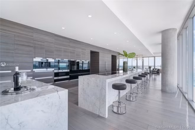 Nhà bếp rộng lớn, được thiết kế theo phong cách vừa cởi mở vừa tối giản. Những trang thiết bị nấu nướng được tích hợp trong một chiếc tủ âm tường khổng lồ. Bên cạnh đó là một quầy bar thu nhỏ với tủ rượu vang.