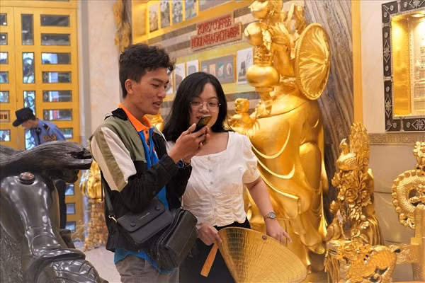 Dù mới đi vào hoạt động cách đây chưa lâu nhưng nhôi nhà dát vàng của vợ chồng anh Trung đã thu hút đông đảo khách đến tham quan. Ngoài ra, trong khuôn viên hơn 1.500m2 của ngôi nhà, gồm khu sân vườn phục vụ cà phê, ăn uống, khách tham quan có thể chiêm ngưỡng dàn cây kiểng 'độc nhất vô nhị', cùng với hàng trăm tấn sỏi, đá được sắp xếp tỉ mỉ và đặc biệt là đèn led về đêm trang hoàng rực rỡ. - Ảnh: Người lao động