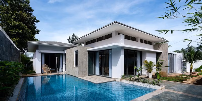 Hồ bơi nằm kín đáo phía sau, bên hông ngôi nhà, tiếp giáp với phòng ăn và phòng ngủ chính.
