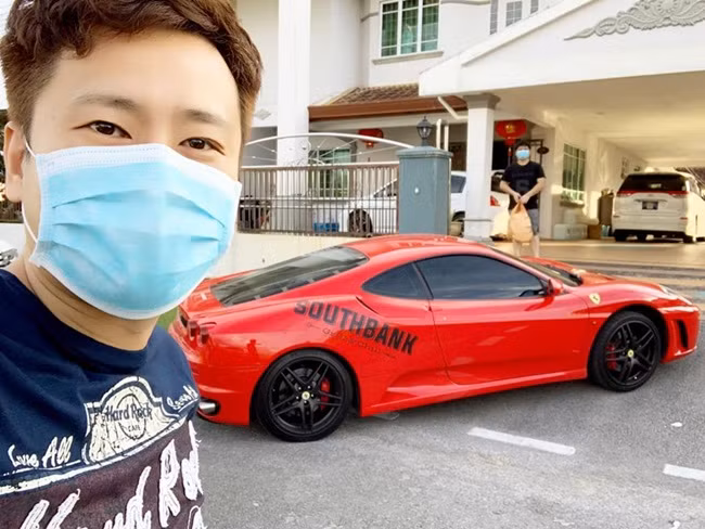 Nhân viên nhà hàng chụp ảnh selfie bên siêu xe màu đỏ khi có đơn hàng khách đặt đưa đến nhà.
