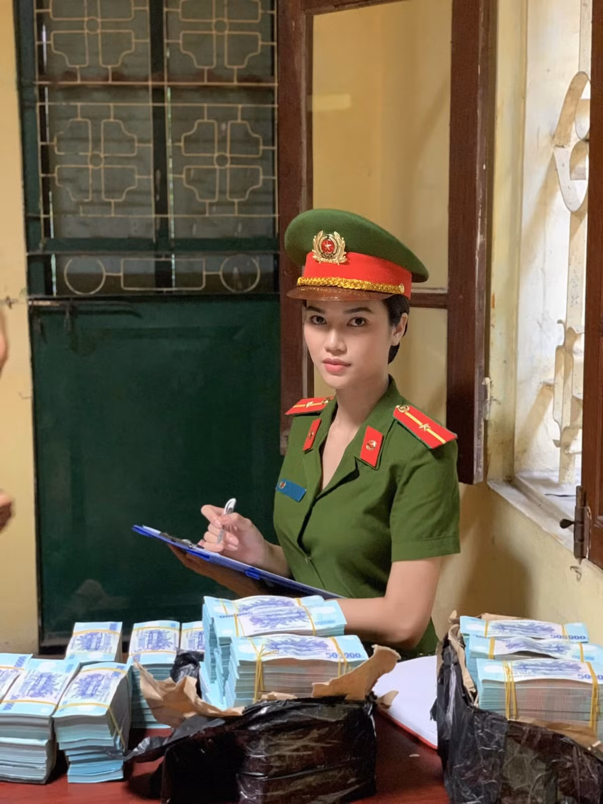 Diễn viên Anh Đào, vai thiếu uý Phương Linh chia sẻ ảnh hậu trường một cảnh quay với các đạo cụ là những sấp tiền mệnh giá lớn.