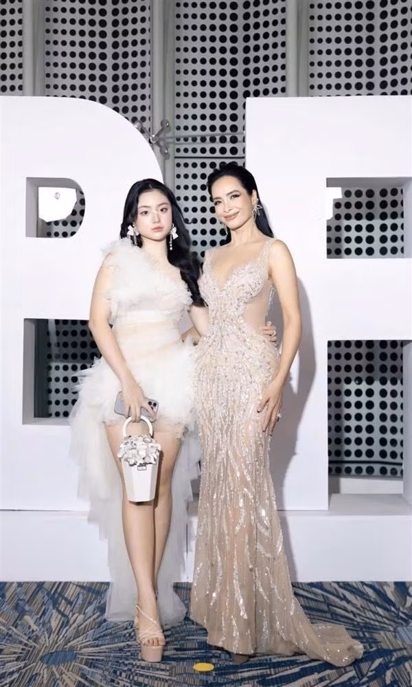 Suti - con gái thứ hai của Thúy Hạnh, thu hút sự chú ý khi cùng mẹ dự sự kiện thời trang. Cô bé diện đầm trắng cách điệu, khoe eo thon và đôi chân dài thừa hưởng từ mẹ, tự tin tạo dáng trước ống kính.