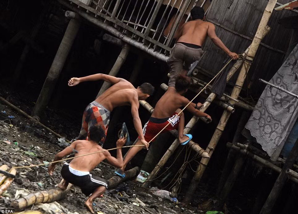 Cư dân thành phố Las Pinas, phía nam Manila vội vã leo lên một khu tránh bão được xây cao hơn so với mặt đất.