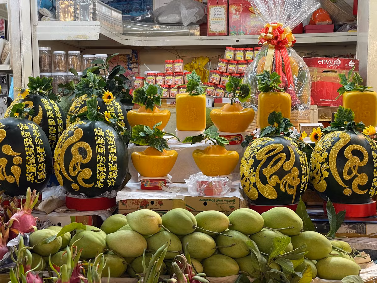 Dưa hấu khắc chữ thư pháp, dưa hình thỏi vàng có giá lên tới cả triệu đồng cũng được bày bán tại chợ chờ khách mua.