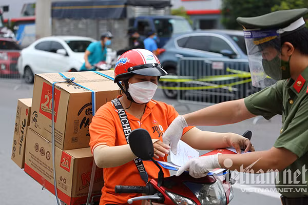 Lực lượng chức năng kiểm tra giấy đi đường của người dân. Ảnh: Phạm Hải