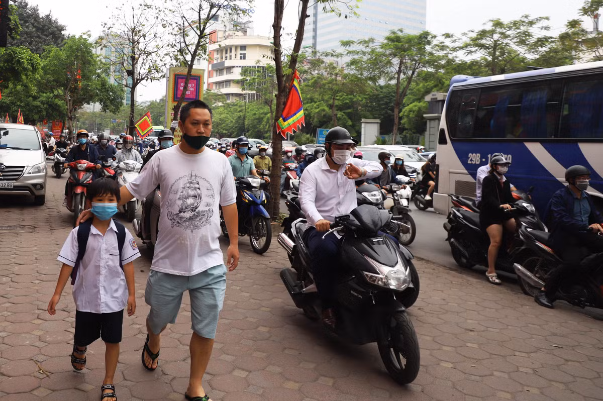 Nhiều người xe máy leo lên phần đường dành cho người đi bộ để băng qua khu vực tắc đường.