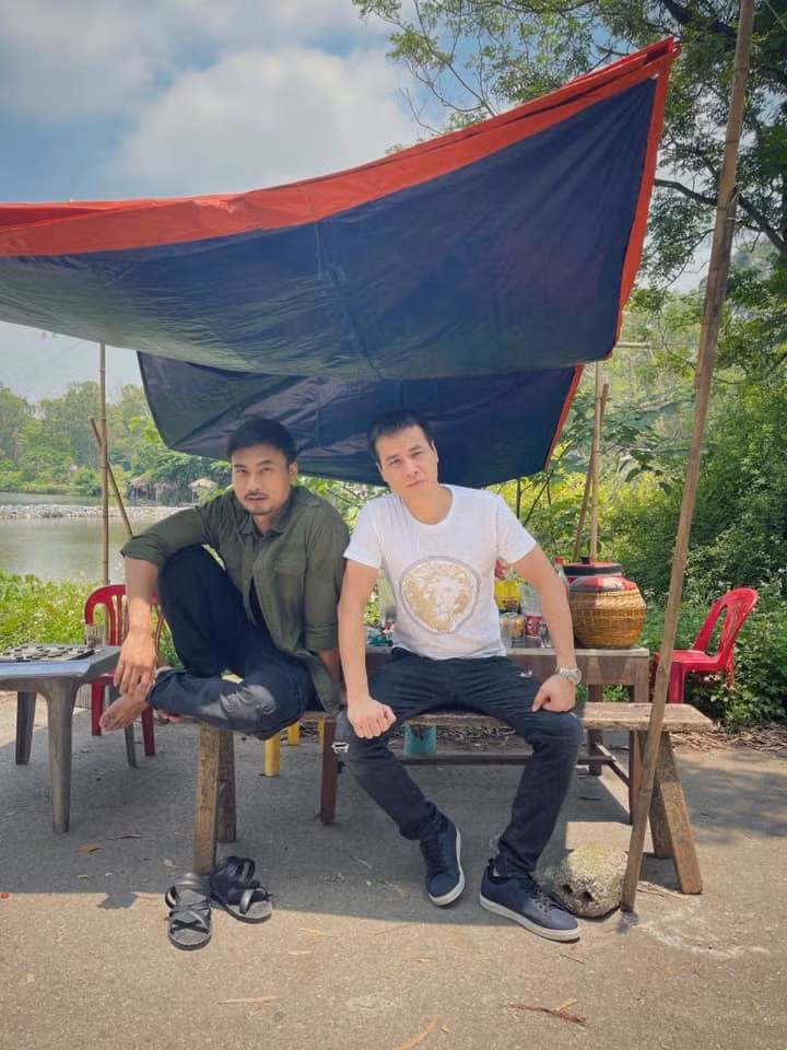 Duy Hưng và Anh Đức ngồi thở ở bối cảnh phim 'Mùa hoa tìm lại' ở ngoại thành Hà Nội trong những ngày nắng nóng.