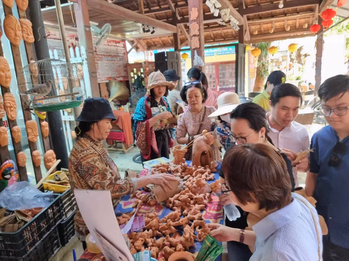 Du khách chọn mua sản phẩm lưu niệm từ gốm.