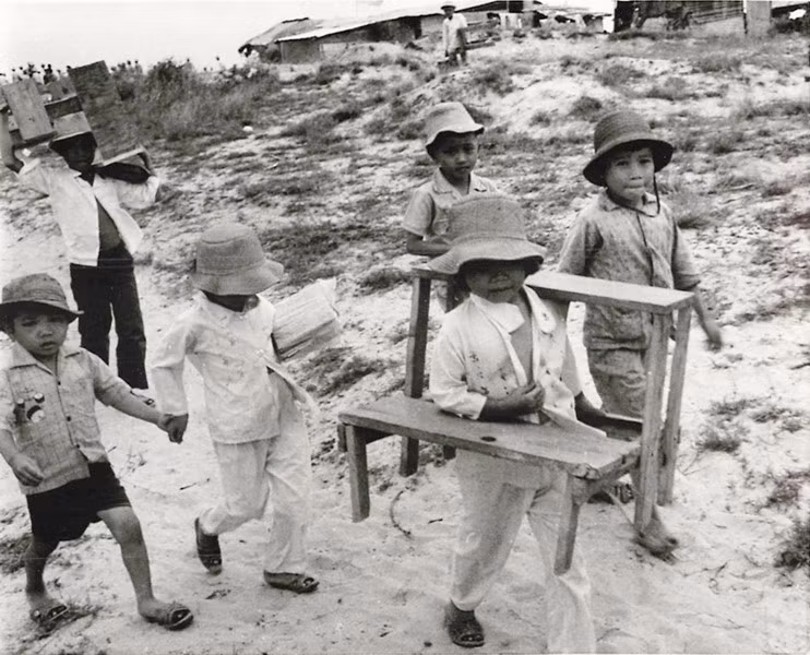 Các học sinh nhỏ bê bàn ghế đến lớp học ngoài trời của mình ở Quảng Trị, ngày 24/9/1973. Trường của các em đã bị phá hủy trong chiến sự năm 1972.