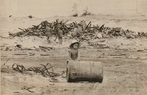 Bé gái lăn chiếc thùng phi từ bãi rác để đem bán phế liệu ở Đà Nẵng, ngày 27/6/1971.
