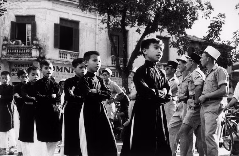 Học sinh Hà Nội mặc áo dài, khoanh tay khi đi qua đường, 23/5/1954.