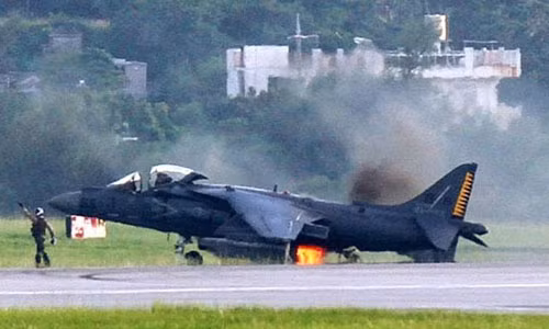 Máy bay cất hạ cánh thẳng đứng AV-8B bốc cháy ở phía sau.
