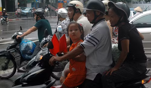 2 tay 2 lá cờ tung tăng cùng cha mẹ trên phố Tây Sơn, Đống Đa, Hà Nội.