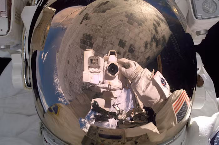Những hình ảnh phản chiếu trong mũ bảo hiểm của kỹ sư máy bay NASA Steve Robinson chính là lá chắn nhiệt của tàu con thoi Discovery.