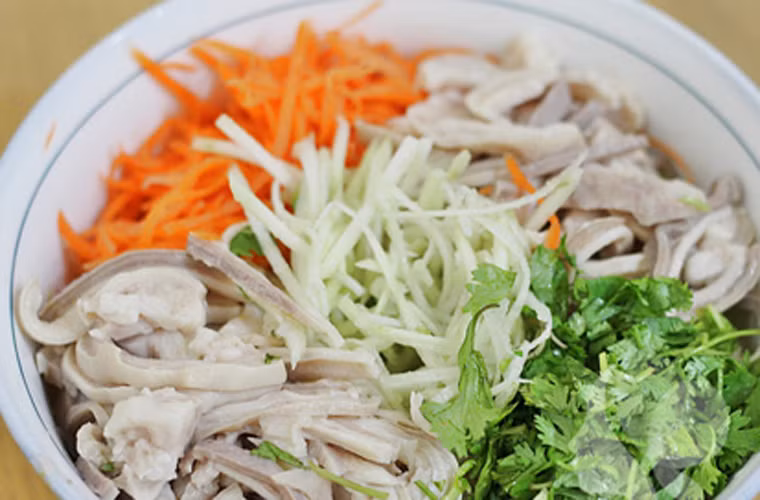 Pha ½ thìa cà phê đường, 1 thìa nước cốt chanh, ½ thìa muối cho vào trộn đều với ổi, cà rốt, dạ dày và rau sống.