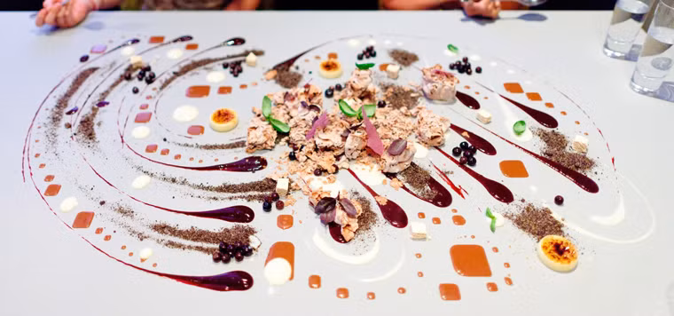 Alinea (Chicago, Mỹ). Điểm nổi bật về phong cách phục vụ tại nhà hàng Alinea là luôn tạo được không gian riêng tư cho khách hàng. Thực khách cũng khá hài lòng với việc tận dụng hiệu ứng ánh sáng phù hợp với tâm trạng và đồ ăn thức uống phục vụ trên bàn tiệc. Một điểm nhấn khác là các món ăn ở đây hầu hết được phục vụ tại bàn để giữ được hương vị và sự nóng hổi hấp dẫn.