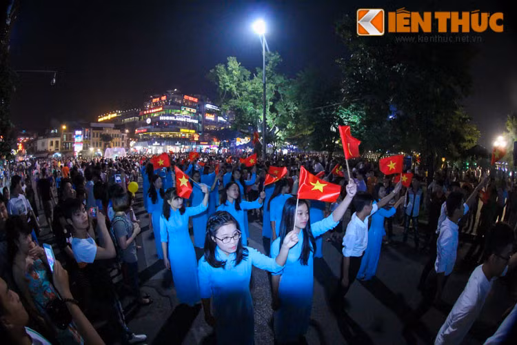 Hình ảnh các thiếu nữ mặc áo dài xanh vẫy cờ đỏ sao vàng khiến rất nhiều người xúc động. Ảnh: Anh Tú.