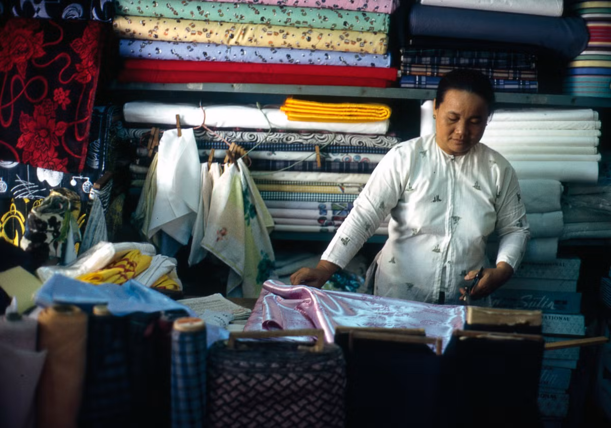 Người thợ may đo cắt áo dài trong một tiệm may. Ảnh: William Ruzin.