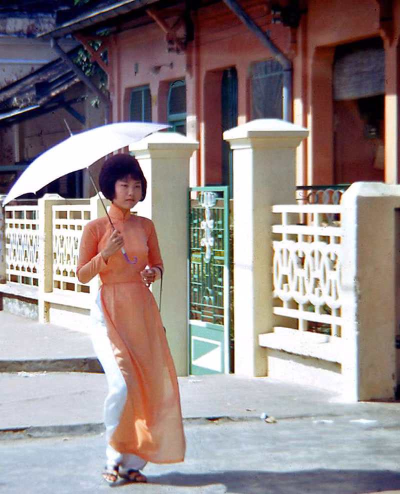 Thiếu nữ áo dài che ô đi trên hè phố Phan Đình Phùng. Ảnh: Waynecam.