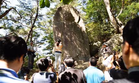 Du khách chụp ảnh bước tượng Phật khắc trên đá tại chùa Haeinsa thuộc tỉnh South Gyeongsang hôm qua, 25/9. Chùa lần đầu tiên công bố bức tượng có từ thế kỷ thứ IX nhân khai mạc lễ hội Tam Tạng Thánh Điển Phật Giáo Hàn Quốc năm 2013, bắt đầu từ ngày 25/9 và kéo dài trong 46 ngày. Ảnh: Shim Hyun-chul.