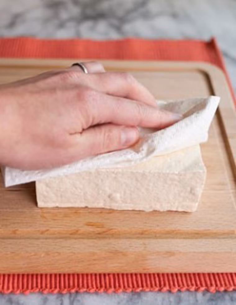 Trường hợp đậu mua về quá mềm hoặc sũng nước, chị em có thể dùng chiếc khăn mỏng quấn quanh đậu rồi dùng vật nặng như viên gạch nhỏ hoặc vài cuốn sách để ép chừng 5 – 10 phút. Bằng cách này, đậu sẽ thơm ngon hơn; hạn chế lượng mỡ trong chảo bắn ra ngoài khi rán.
