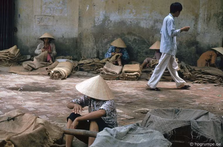 Thợ may bao bố làm việc trên hè phố.