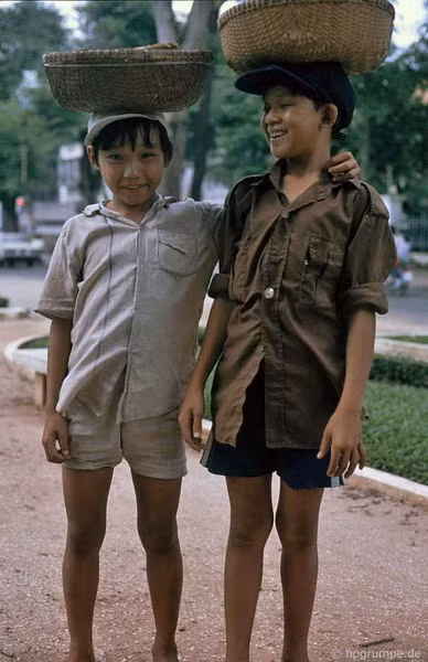 Hai cậu bé bán hàng rong này là anh em ruột, có cha làm nghề kéo xe thuê.